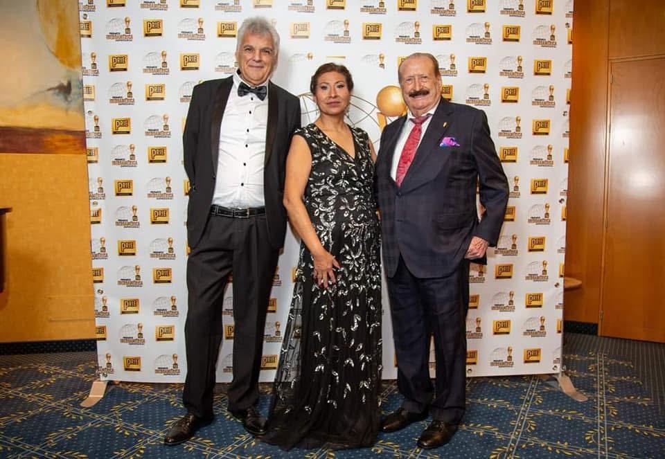 Invitados posando ante el backdrop de los premios